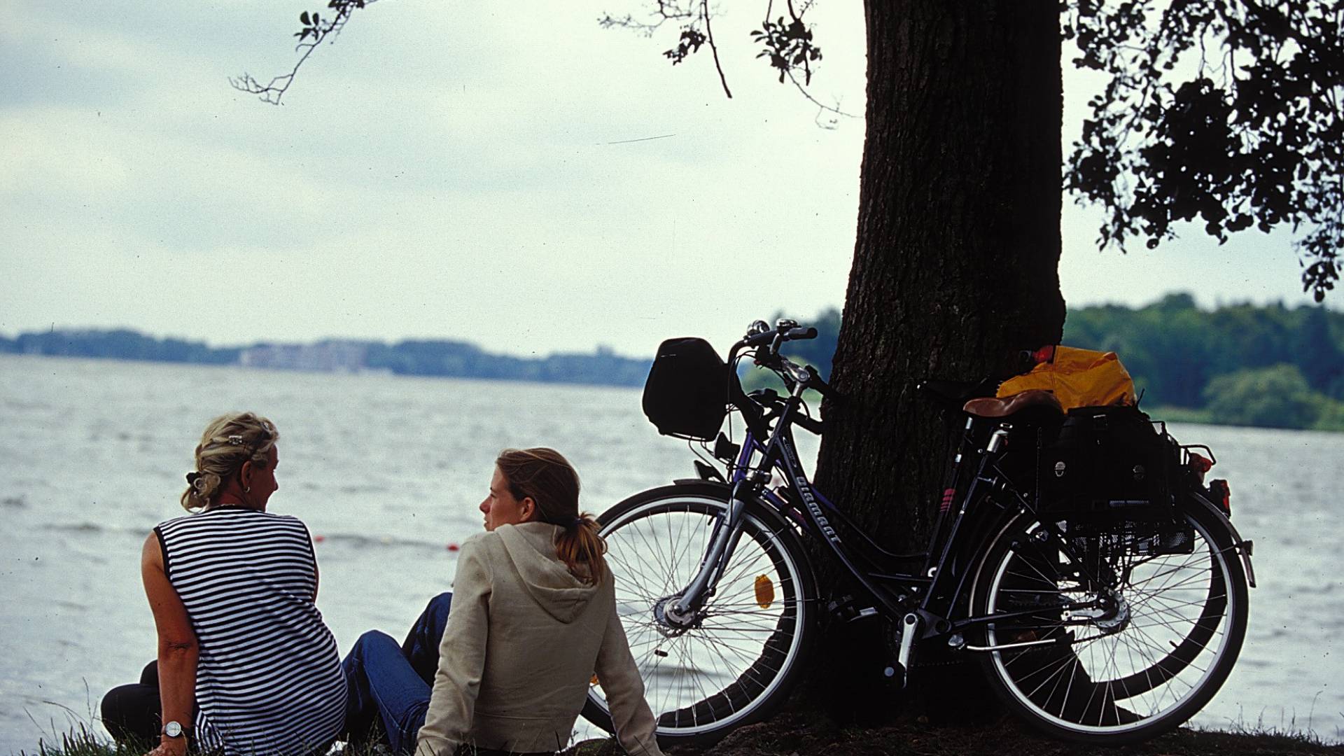 Frauen mit Fahrrädern am See