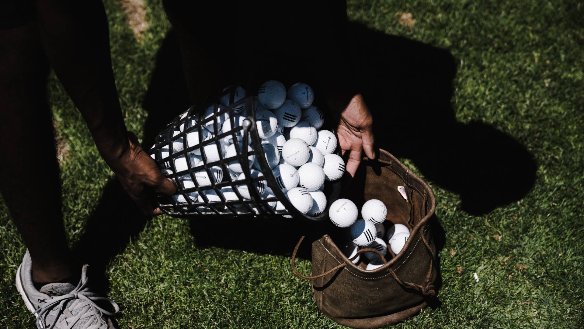 Man pouring golf balls into bag