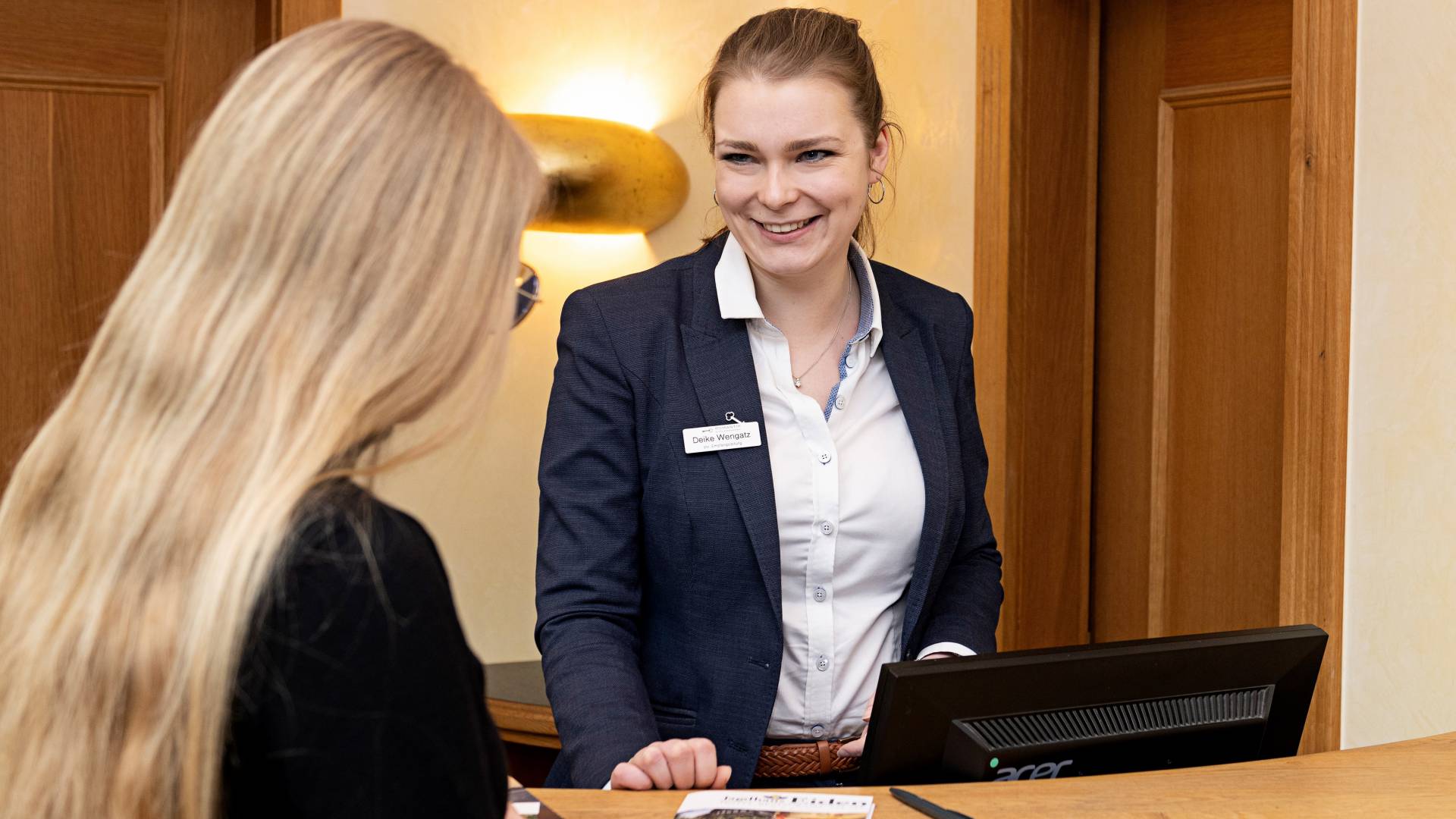 Hotelrezeption im Jagdhaus Eiden mit Rezeptionistin und Gast